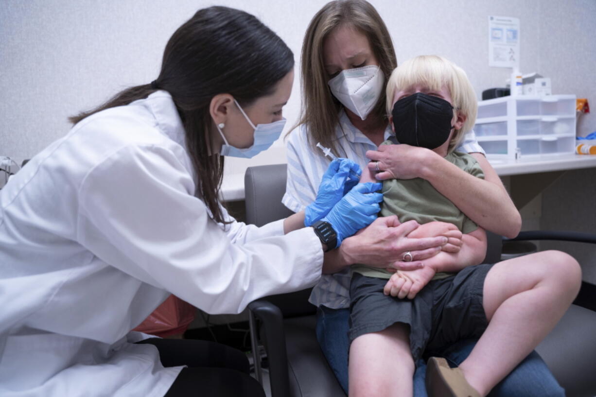 Pharmacist Kaitlin Harring, left, administers a Moderna COVID-19 vaccination to three year-old Fletcher Pack, while he sits on the lap of his mother, McKenzie Pack, at Walgreens pharmacy Monday, June 20, 2022, in Lexington, S.C. Today marked the first day COVID-19 vaccinations were made available to children under 5 in the United States.