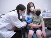 Pharmacist Kaitlin Harring, left, administers a Moderna COVID-19 vaccination to three year-old Fletcher Pack, while he sits on the lap of his mother, McKenzie Pack, at Walgreens pharmacy Monday, June 20, 2022, in Lexington, S.C. Today marked the first day COVID-19 vaccinations were made available to children under 5 in the United States.