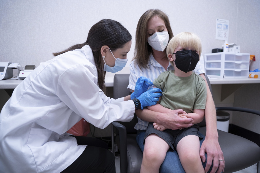 Pharmacist Kaitlin Harring, left, administers a Moderna COVID-19 vaccination to three year-old Fletcher Pack, while he sits on the lap of his mother, McKenzie Pack, at Walgreens pharmacy Monday, June 20, 2022, in Lexington, S.C. Today marked the first day COVID-19 vaccinations were made available to children under 5 in the United States.