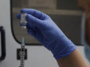 FILE - A vial of the Phase 3 Novavax coronavirus vaccine is seen ready for use in the trial at St. George's University hospital in London, Oct. 7, 2020. The Novavax COVID-19 vaccine that could soon win federal approval may offer a boost for the U.S. military: an opportunity to get shots into some of the thousands of service members who have refused the vaccine for religious reasons.