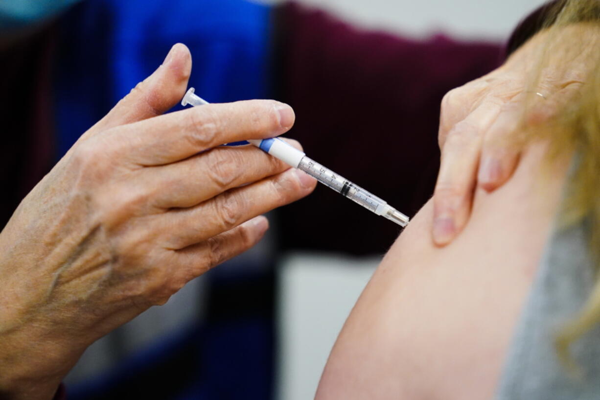 FILE - A health worker administers a dose of a COVID-19 vaccine during a vaccination clinic at the Keystone First Wellness Center in Chester, Pa., on Dec. 15, 2021. Government advisers are debating Tuesday, June 28, 2022, if Americans should get a modified COVID-19 booster shot this fall -- one that better matches more recent virus variants.