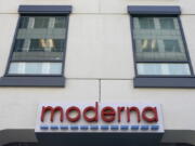 FILE - In this Dec. 15, 2020, file photo, a sign for Moderna, Inc. hangs on its headquarters in Cambridge, Mass.  Moderna's experimental COVID-19 vaccine that combines its original shot with protection against the omicron variant appears to work, the company announced Wednesday, June 8, 2022.