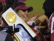 Oklahoma players celebrate with the trophy after defeating Texas in the NCAA softball Women's College World Series finals Thursday, June 9, 2022, in Oklahoma City.