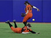 Oregon State outfielders Eliana Gottlieb (12) and Kaylah Nelson (5) miss an Arizona hit to the outfield during the second inning of an NCAA softball Women's College World Series game Friday, June 3, 2022, in Oklahoma City.