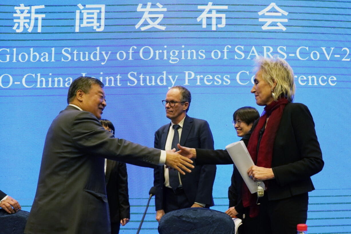 FILE - Marion Koopmans, right, and Peter Ben Embarek, center, of the World Health Organization team say farewell to their Chinese counterpart Liang Wannian, left, after a WHO-China Joint Study Press Conference at the end of the WHO mission in Wuhan, China on Feb. 9, 2021. Experts drafted by the World Health Organization to help investigate the origins of the coronavirus pandemic say further research is needed to determine how COVID-19 first began. They say they need a more detailed analysis of the possibility it was a laboratory accident.