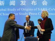 FILE - Marion Koopmans, right, and Peter Ben Embarek, center, of the World Health Organization team say farewell to their Chinese counterpart Liang Wannian, left, after a WHO-China Joint Study Press Conference at the end of the WHO mission in Wuhan, China on Feb. 9, 2021. Experts drafted by the World Health Organization to help investigate the origins of the coronavirus pandemic say further research is needed to determine how COVID-19 first began. They say they need a more detailed analysis of the possibility it was a laboratory accident.