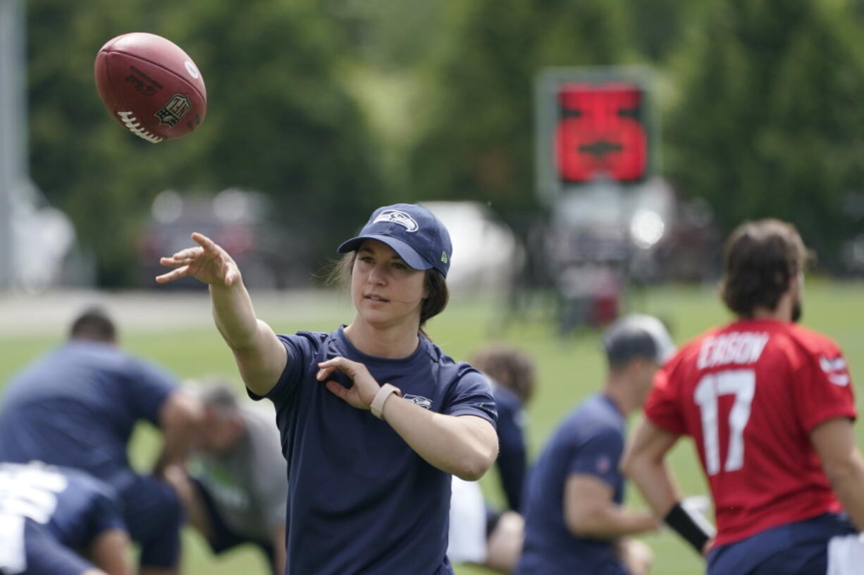 Amanda Ruller, who is currently working as an assistant running backs coach for the NFL football Seattle Seahawks through the league's Bill Walsh Diversity Fellowship program, passes a football during NFL football practice on June 8, 2022, in Renton, Wash. Ruller's job is scheduled to run through the Seahawks' second preseason game in August. (AP Photo/Ted S.