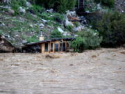 In this photo provided by Sam Glotzbach, the fast-rushing Yellowstone River flooded what appeared to be a small boathouse in Gardiner, Mont., on Monday, June 13, 2022, just north of Yellowstone National Park.