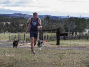 Lew Hollander runs up the driveway of his home in Terrebonne, Ore.