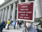 FILE - A person holds a sign referencing the U.S. Supreme Court as they take part in a rally in favor of abortion rights on the steps of the Temple of Justice, which houses the Washington state Supreme Court, Tuesday, May 3, 2022, at the Capitol in Olympia, Wash. (AP Photo/Ted S.