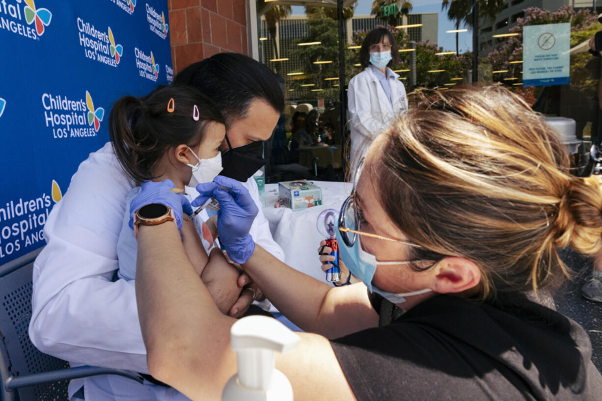 Sofia Espinoza Tam is held by her father, Children's Hospital Los Angeles pediatrician Dr. Juan Espinoza, while nurse Monica Lopez administers the Pfizer COVID-19 vaccine on June 21.