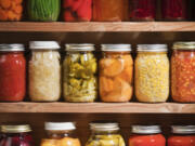 Wooden shelves hold varieties of canned vegetables and fruits.