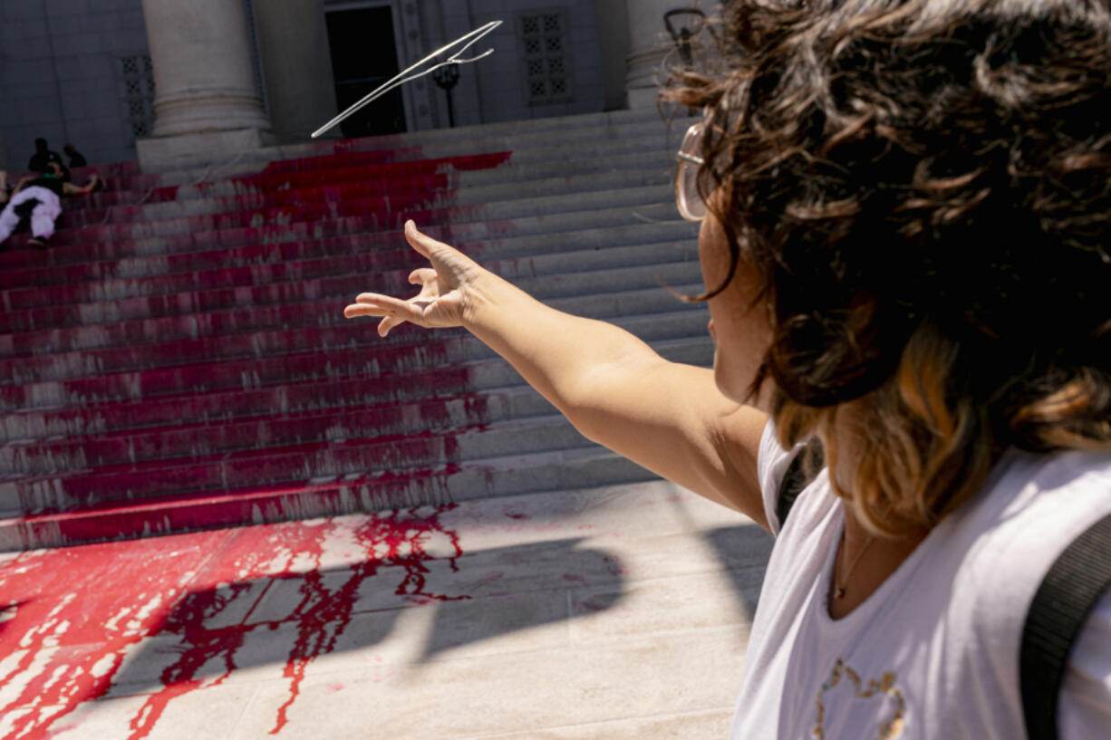 A protester throws a coat hanger representing unsafe abortions outside Los Angeles City Hall.