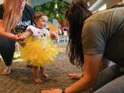 Blue Haven Ranch chairman Brittany White, right, sings and acts out "The Ants Go Marching," with Victoria Gwynn, 1, and her mother Gabbie Gwynn, left, at Victoria's first birthday party July 11 at Oak Hills Community Church in Argyle, Texas.