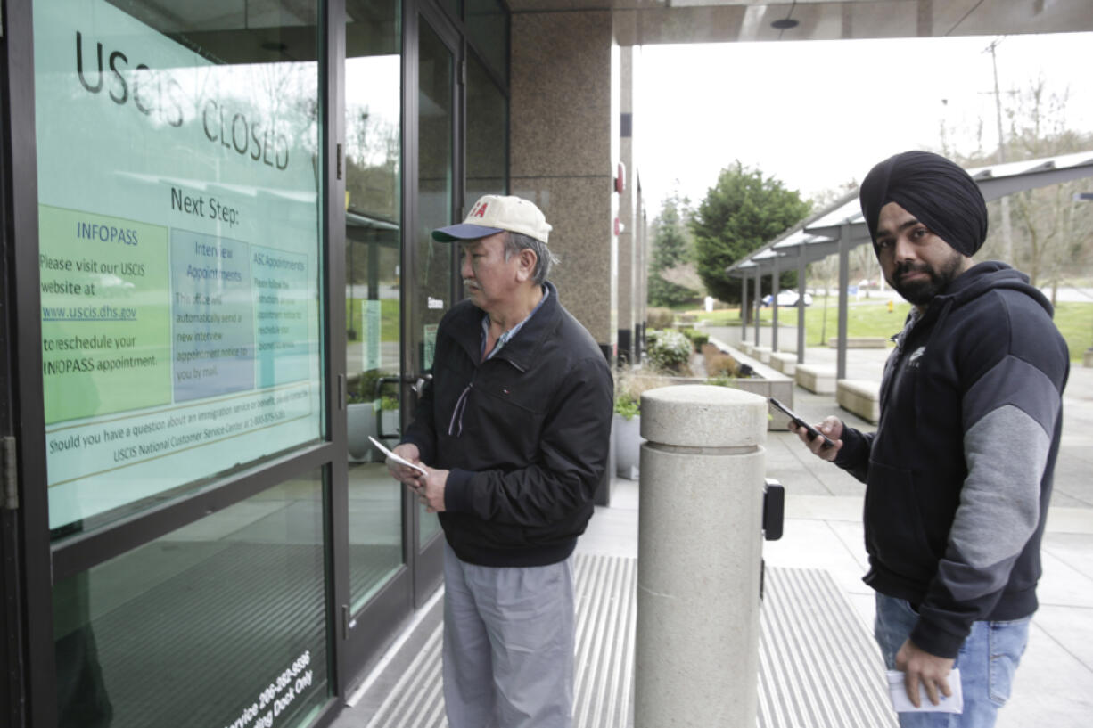 People read an informational sign following a two-week closure of a Department of Homeland Security building and U.S. Citizenship and Immigration Services field office because of an employee who may be infected with the novel coronavirus in Tukwila, Washington, on March 3, 2020.