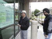 People read an informational sign following a two-week closure of a Department of Homeland Security building and U.S. Citizenship and Immigration Services field office because of an employee who may be infected with the novel coronavirus in Tukwila, Washington, on March 3, 2020.