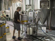 Co-owner Mark Doleski works behind the scenes at Fortside Brewing Company in Vancouver while his partner, Mike DiFabio, looks on. Fortside is joining a lawsuit that aims to make the Oregon beer market easier to access.