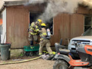 Clark-Cowlitz firefighters extinguish a fire that destroyed a manufactured home north of Lewisville Park Thursday.