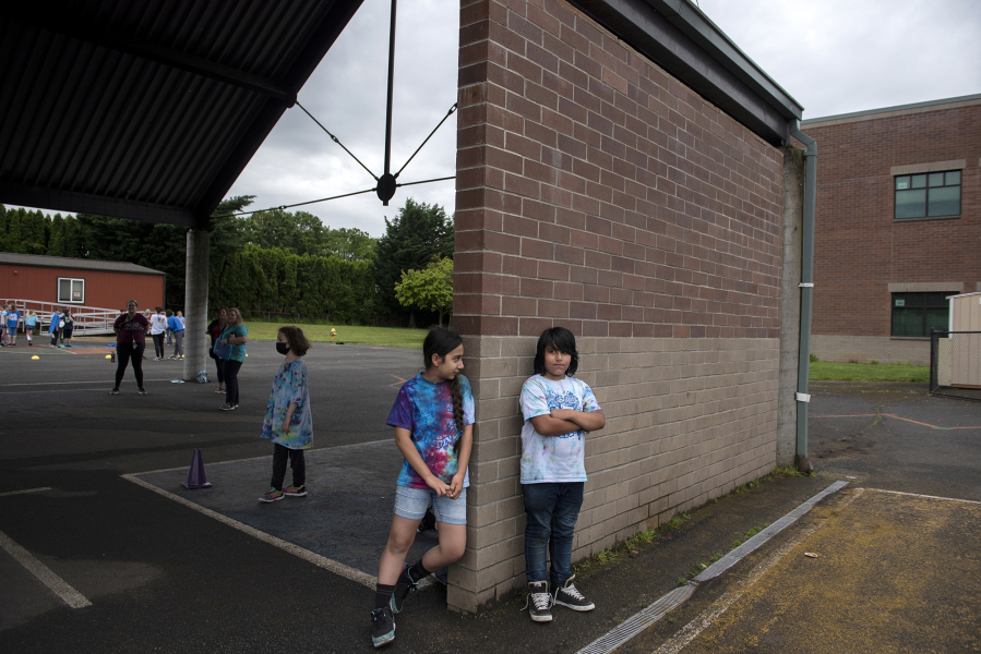 Hazel Dell Elementary School fifth-grader Marwa Azizpour, 10, left, pauses on field day in June to comfort classmate Isaiah Colin-Miranda, who was ruled "out" during a schoolyard game.