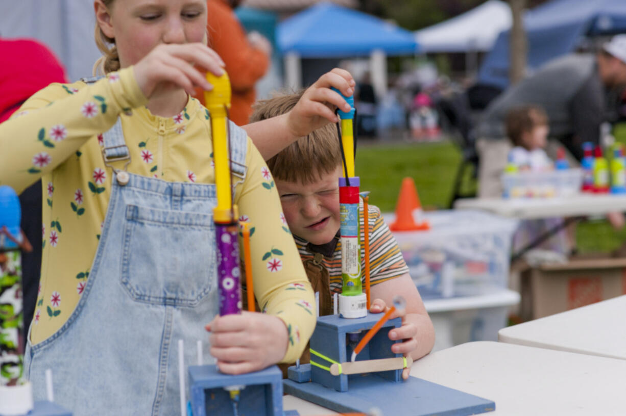 The Columbia Play Project's Pop-Up in the Park is a series of free, public events designed to engage children at various locations throughout the summer. Saturday's pop-up was in Ridgefield's Overlook Park. Jasper Hutchins, 9, right, aims for a target with his sister Daisy Hutchins, 11, using tiny rocket launchers that operate using compressed air.