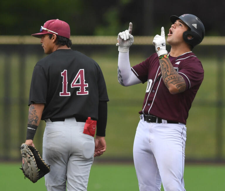 Raptors first baseman Safea Mauai, right, points and celebrates after a hit Wednesday, July 6, 2022, during a game between the Ridgefield Raptors and the Corvallis Knights at the Ridgefield Outdoor Recreation Complex.