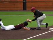 Raptors center fielder Austin Caviness, left, is tagged out sliding into third by Knights third baseman Mason Le on Wednesday, July 6, 2022, during a game between the Ridgefield Raptors and the Corvallis Knights at the Ridgefield Outdoor Recreation Complex.