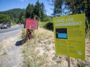 A motorist traveling on Northeast Healy Road passes a sign notifying neighbors about renewed Clark County procedures that could eventually lead to gravel mining.