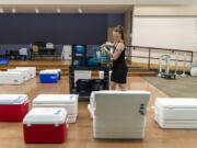 Share kitchen assistant Maddie May loads coolers with ice packs at St. Joseph Catholic Church in Vancouver. The organization is helping low-income students get proper nutrition in the summer.