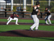 Raptors shortstop Travis Welker, left, begins to dash back to first base Tuesday, July 26, 2022, during a game between Ridgefield and the Bend Elks at the Ridgefield Outdoor Recreation Complex.