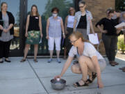 Bridget Burke of Central Kitsap Middle School drops a store-bought bath bomb into water while taking part in an instructional seminar as part of the state's new OpenSciEd initiative, which engages in project-based learning in science, at Evergreen Public Schools' headquarters in Vancouver on Tuesday afternoon. The teachers were learning more about the chemical reactions in the bath bomb.