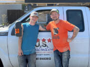 Corbin Cavagna, left, and Timothy Ward pose with their U.S. Construction truck. On their way to a job site Thursday morning, they spotted a house fire in the Barberton area and helped rescue an 11-year-old girl from inside.