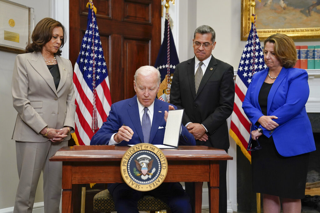 President Joe Biden signs an executive order on abortion access during an event in the Roosevelt Room of the White House, Friday, July 8, 2022, in Washington. From left, Vice President Kamala Harris, Health and Human Services Secretary Xavier Becerra, and Deputy Attorney General Lisa Monaco look on.