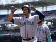 Seattle Mariners' Eugenio Suarez reacts after hitting a three-run home run in the first inning of the first game of a baseball doubleheader against the Washington Nationals, Wednesday, July 13, 2022, in Washington.