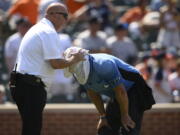 Baltimore Orioles head trainer Brian Ebel, left, helps home plate umpire Scott Barry get relief with a wet towel around his head after the sixth inning of a baseball game between the Orioles and the New York Yankees, Sunday, July 24, 2022, in Baltimore. The Yankees won 5-0.