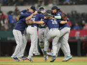 The Seattle Mariners dance in a circle after the final out of the baseball game against the Texas Rangers in Arlington, Texas, Sunday, July 17, 2022. The Mariners won 6-2.