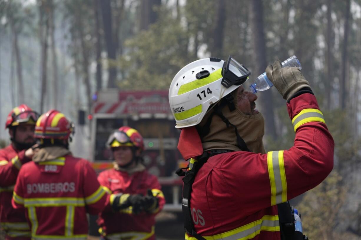 A firefighter washes his eyes with water in the village of Colmeias, near Leiria, central Portugal, Wednesday, July 13, 2022. Thousands of firefighters in Portugal continue to battle fires all over the country that forced the evacuation of dozens of people from their homes.