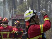 A firefighter washes his eyes with water in the village of Colmeias, near Leiria, central Portugal, Wednesday, July 13, 2022. Thousands of firefighters in Portugal continue to battle fires all over the country that forced the evacuation of dozens of people from their homes.