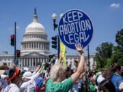 FILE - Abortion-rights activists demonstrate against the Supreme Court decision to overturn Roe v. Wade that established a constitutional right to abortion, on Capitol Hill in Washington, June 30, 2022. A majority of Americans say Congress should pass a law guaranteeing access to legal abortion nationwide. That's according to a new poll from The Associated Press-NORC Center for Public Affairs Research. (AP Photo/J.