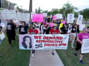 FILE - Thousands of protesters march around the Arizona Capitol in protest after the Supreme Court decision to overturn the landmark Roe v. Wade abortion decision Friday, June 24, 2022, in Phoenix. The U.S. Supreme Court ruling overturning Roe v. Wade has legal advocates, prosecutors and residents of red states facing a legal morass created by decades of often conflicting anti-abortion legislation. In Arizona, Republicans are fighting among themselves over whether a 121-year-old anti-abortion law that precedes statehood should be enforced over a 2022 version. (AP Photo/Ross D.