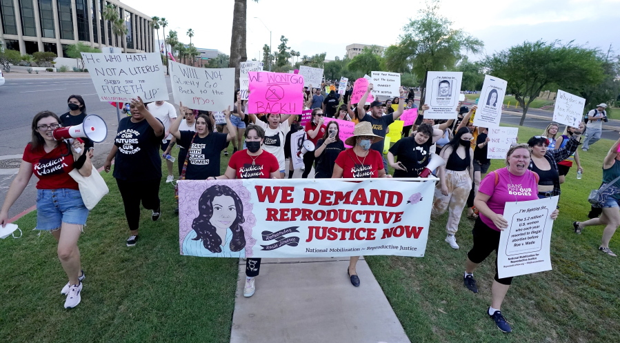 FILE - Thousands of protesters march around the Arizona Capitol in protest after the Supreme Court decision to overturn the landmark Roe v. Wade abortion decision Friday, June 24, 2022, in Phoenix. The U.S. Supreme Court ruling overturning Roe v. Wade has legal advocates, prosecutors and residents of red states facing a legal morass created by decades of often conflicting anti-abortion legislation. In Arizona, Republicans are fighting among themselves over whether a 121-year-old anti-abortion law that precedes statehood should be enforced over a 2022 version. (AP Photo/Ross D.