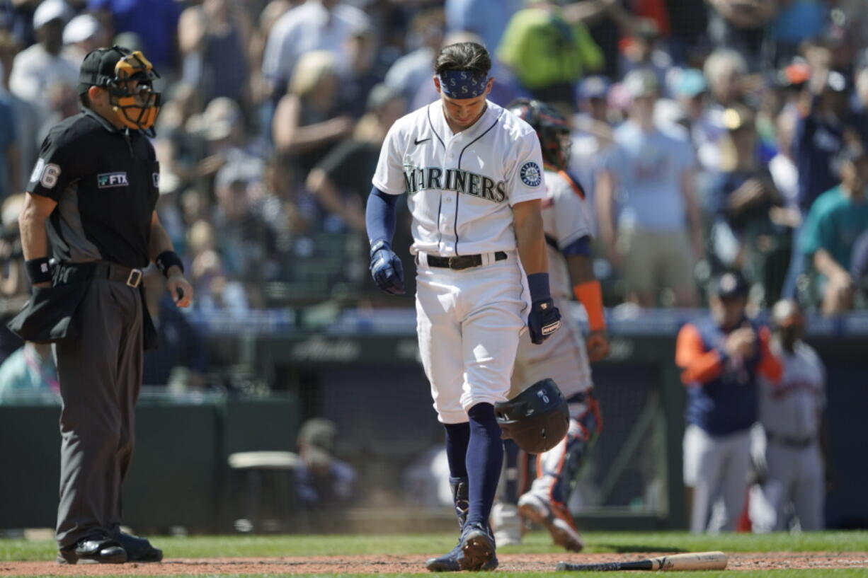 Seattle Mariners' Sam Haggerty drops his helmet and bat after he was out on a foul tip with the bases loaded to end the seventh inning. (Ted S.