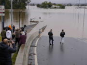 People look at the flooded Windsor Bridge at Windsor on the outskirts of Sydney, Australia, Tuesday, July 5, 2022.