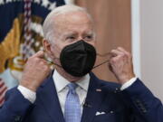 FILE - President Joe Biden removes his face mask as he arrives to speak about the economy during a meeting with CEOs in the South Court Auditorium on the White House complex in Washington, Thursday, July 28, 2022. Biden tested positive for COVID-19 again Saturday, July 30, slightly more than three days after he was cleared to exit coronavirus isolation, the White House said, in a rare case of "rebound" following treatment with an anti-viral drug.