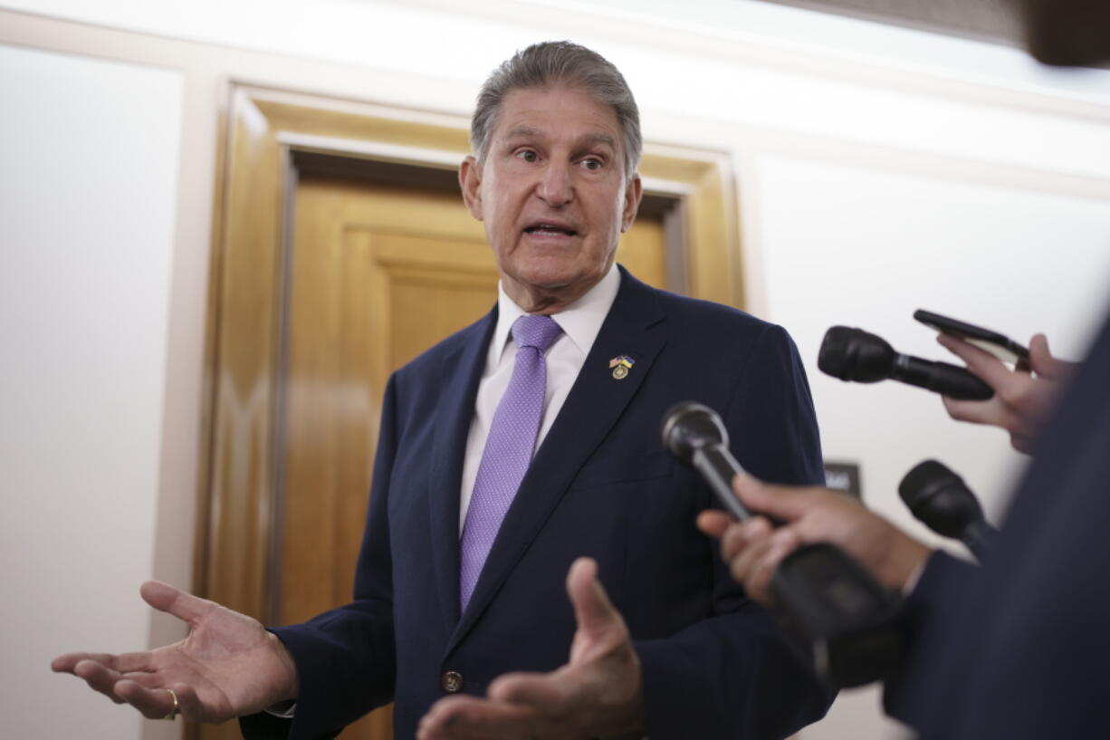 FILE - Sen. Joe Manchin, D-W.Va., is met by reporters outside the hearing room where he chairs the Senate Committee on Energy and Natural Resources, at the Capitol in Washington, July 21, 2022. Manchin has been an obstacle for Biden's climate change plans, a reflection of his outsized influence at a time when Democrats hold the narrowest of margins in the U.S. Senate. (AP Photo/J.