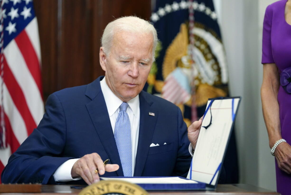 FILE - President Joe Biden signs into law S. 2938, the Bipartisan Safer Communities Act gun safety bill, in the Roosevelt Room of the White House in Washington, Saturday, June 25, 2022.