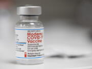 FILE - A vial of the Moderna COVID-19 vaccine is displayed on a counter at a pharmacy in Portland, Ore. on Dec. 27, 2021. The Biden administration said Friday it has reached an agreement to buy 66 million doses of Moderna's next generation of COVID-19 vaccine that specifically targets the highly transmissible omicron variant, ensuring enough supply this winter for everyone who wants the upgraded booster.