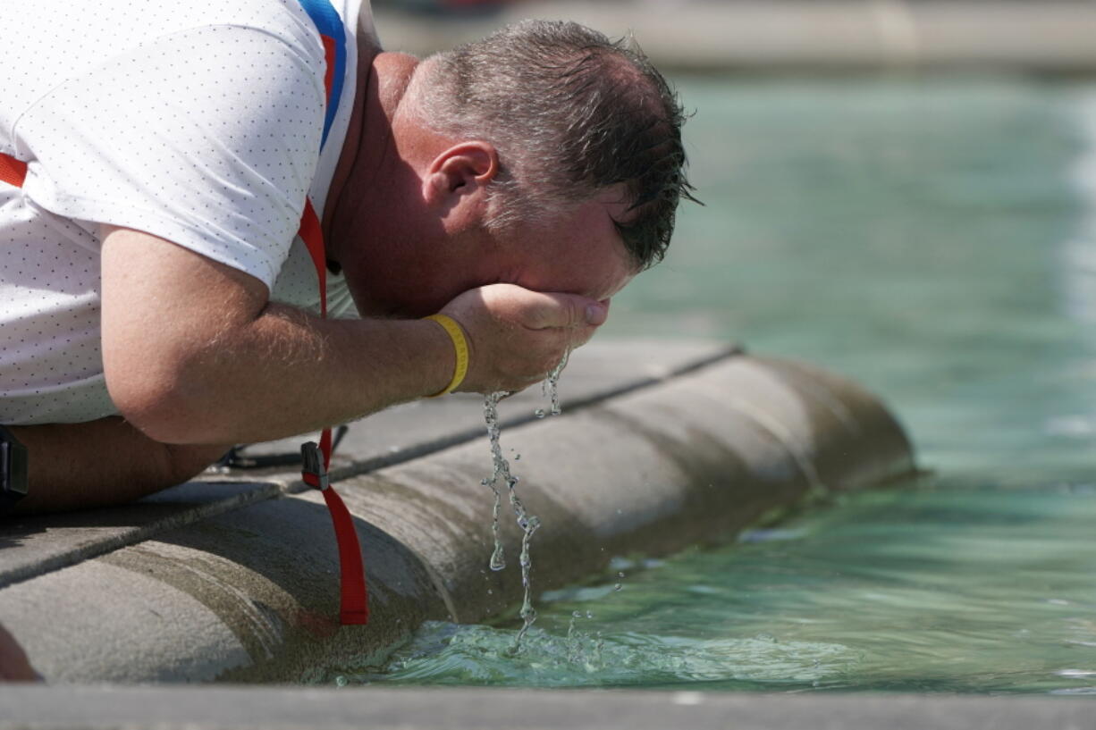 A man refreshes his face at a fountain in Trafalgar Square in central London, Tuesday, July 19, 2022. Britain shattered its record for highest temperature ever registered Tuesday, with a provisional reading of 39.1 degrees Celsius (102.4 degrees Fahrenheit), according to the country's weather office -- and the heat was only expected to rise.