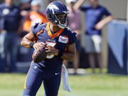 Denver Broncos quarterback Russell Wilson takes part in drills during the opening session of the NFL football team's training camp Wednesday, July 27, 2022, in Centennial, Colo.