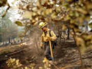 Firefighter Sergio Porras mops up hot spots while battling the Oak Fire in the Jerseydale community of Mariposa County, Calif., on Monday, July 25, 2022. He is part of Task Force Rattlesnake, a program comprised of Cal Fire and California National Guard firefighters.