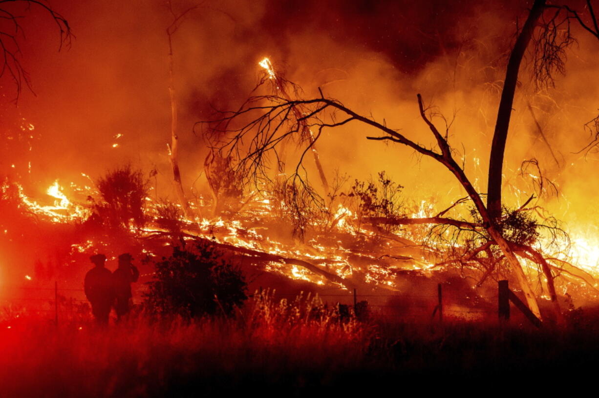 Firefighters battle the Electra Fire in the Rich Gulch community of Calaveras County, Calif., on Monday, July 4, 2022. According to Amador County Sheriff Gary Redman, approximately 100 people sheltered at a Pacific Gas & Electric facility before being evacuated in the evening.